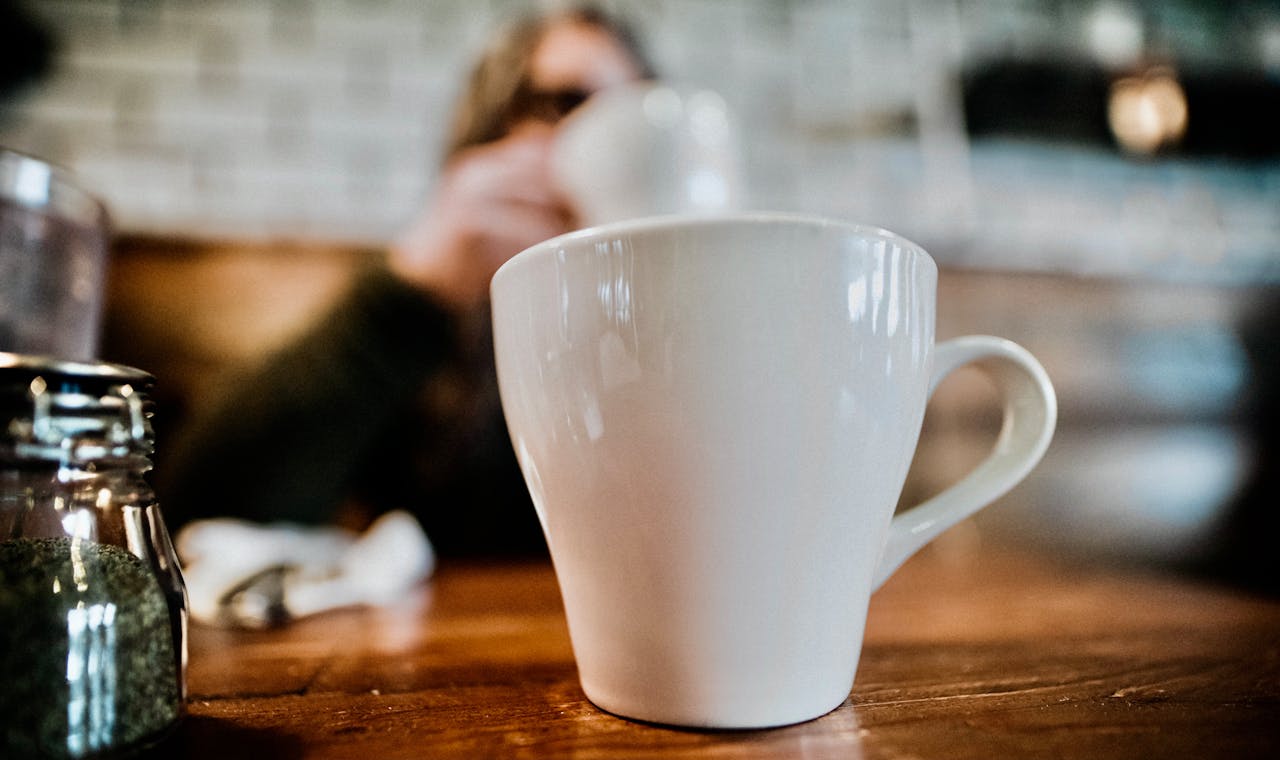 services-img Enjoy a warm coffee moment with a blurred background for a cozy café vibe.